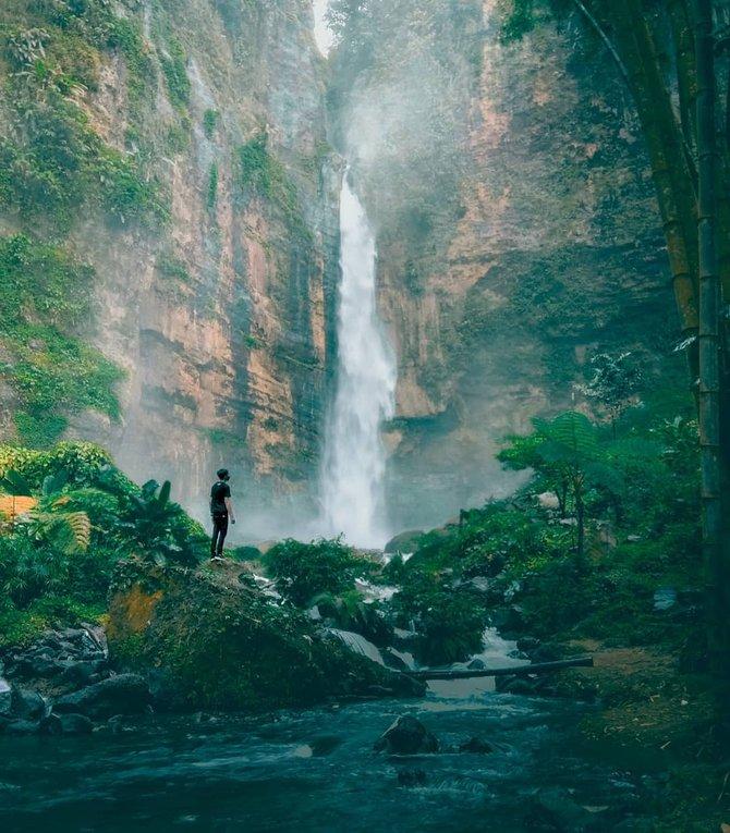Air Terjun Kapas Biru jatuh dari tebing tinggi di tengah hutan Pronojiwo, Lumajang