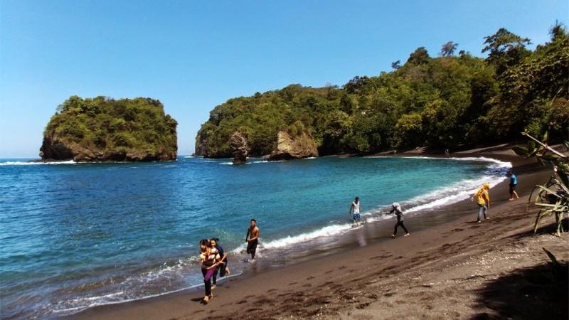 Pantai Dampar dengan pasir hitam, tebing karang, dan ombak Samudra Hindia di Pasirian, Lumajang